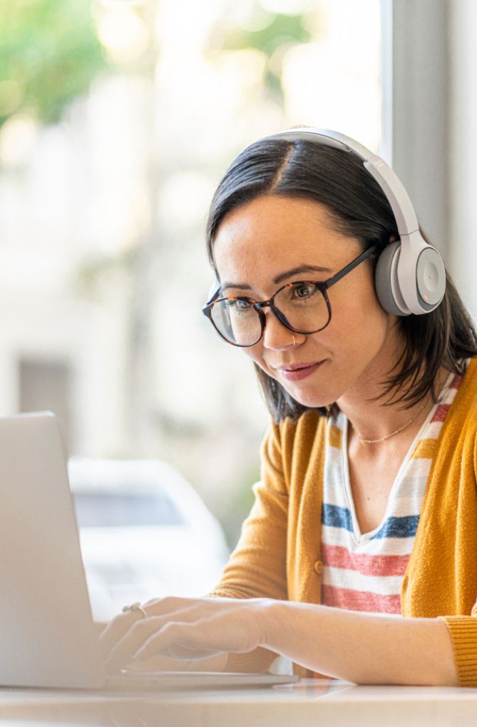 young woman on laptop with headphones on